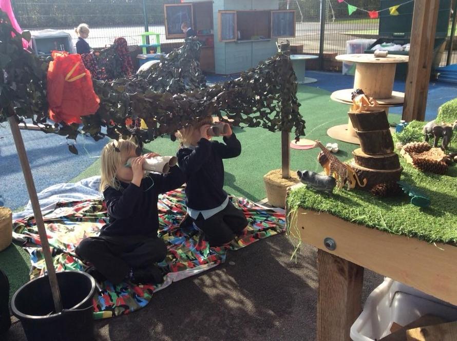 Children in a den using binoculars