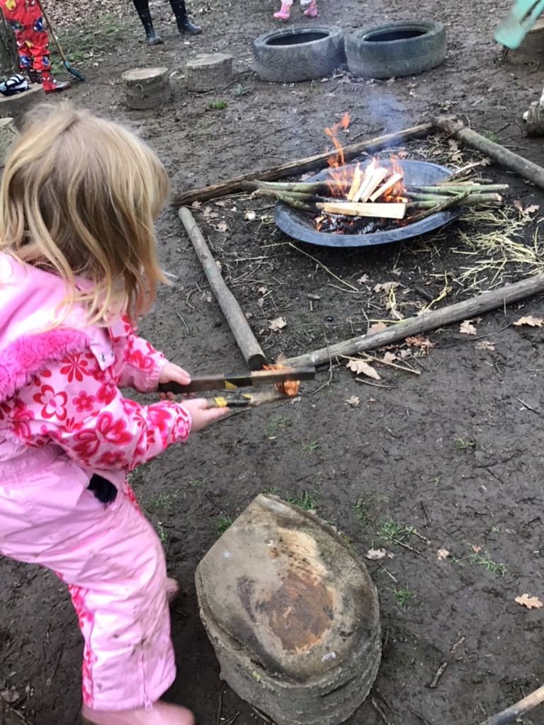 Child looking a forest school fire 