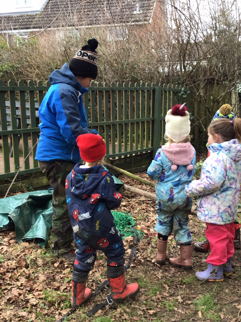 Children gathering wood with forest school leader